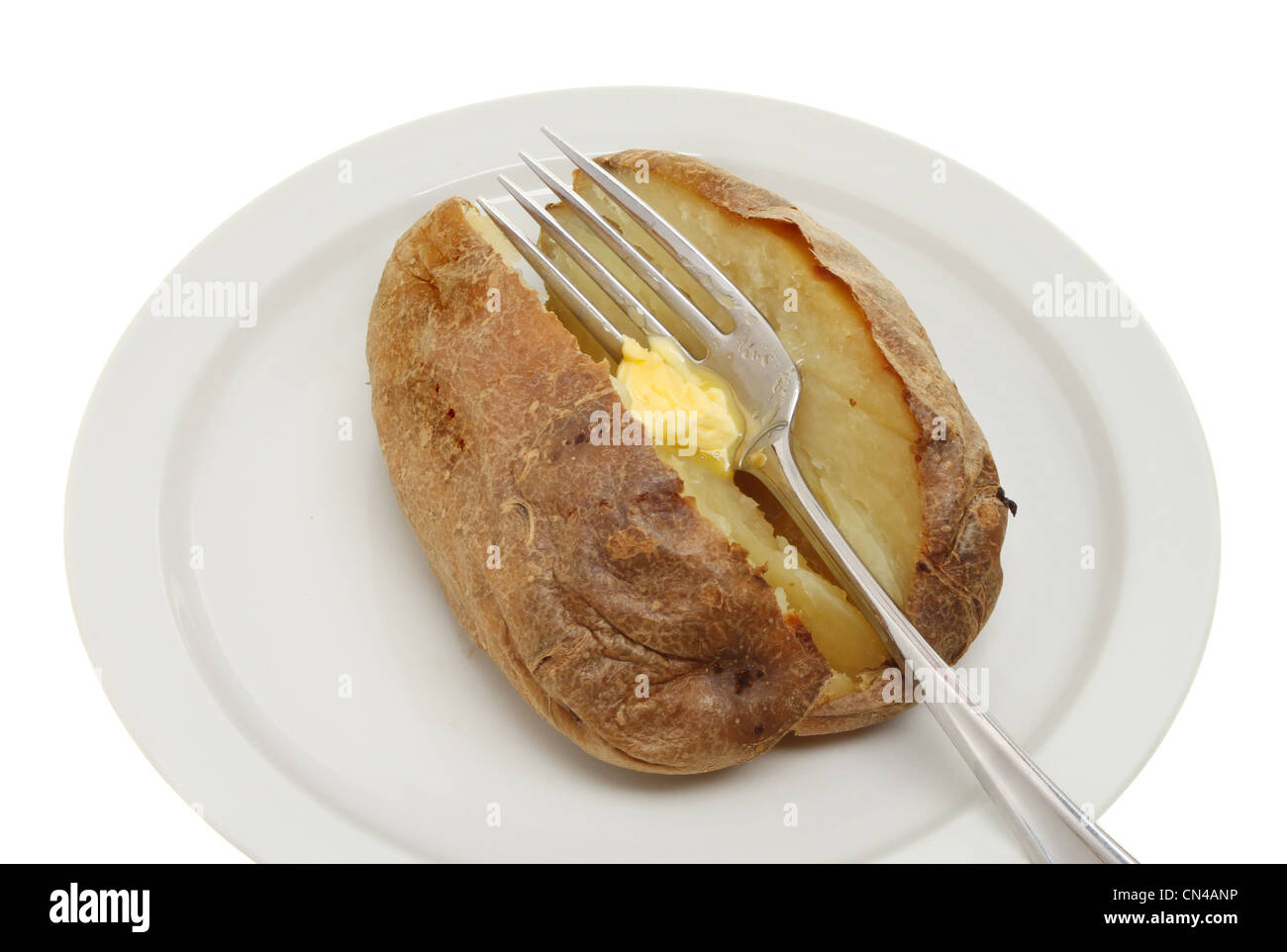Primo piano di una pianura di patate al forno con burro di fusione su una forcella Foto Stock