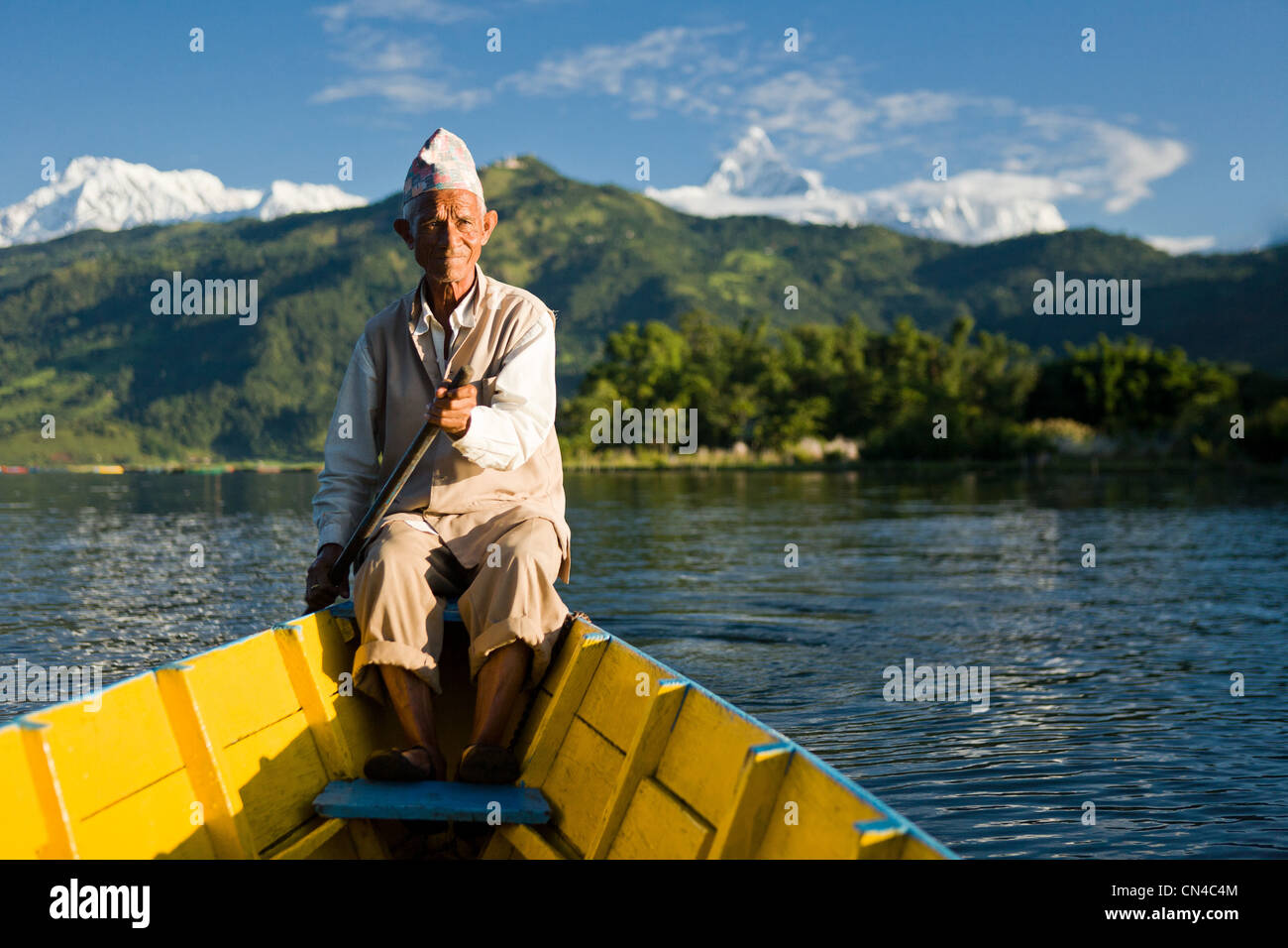 Uomo nepalese a remi in barca tradizionale Foto Stock