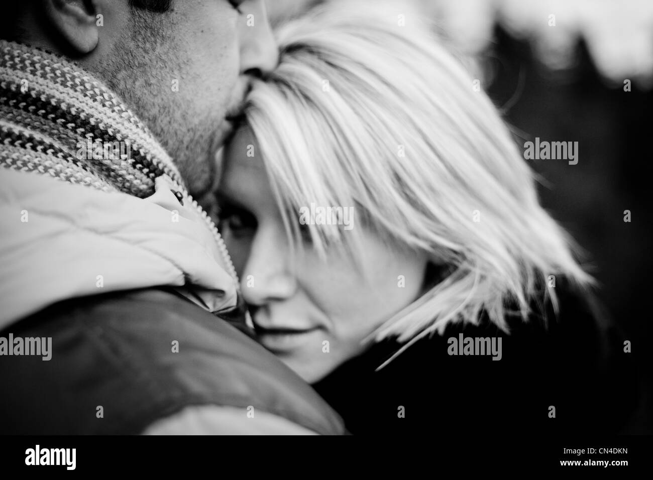 Un momento intimo tra una coppia con un bacio alla testa Foto Stock