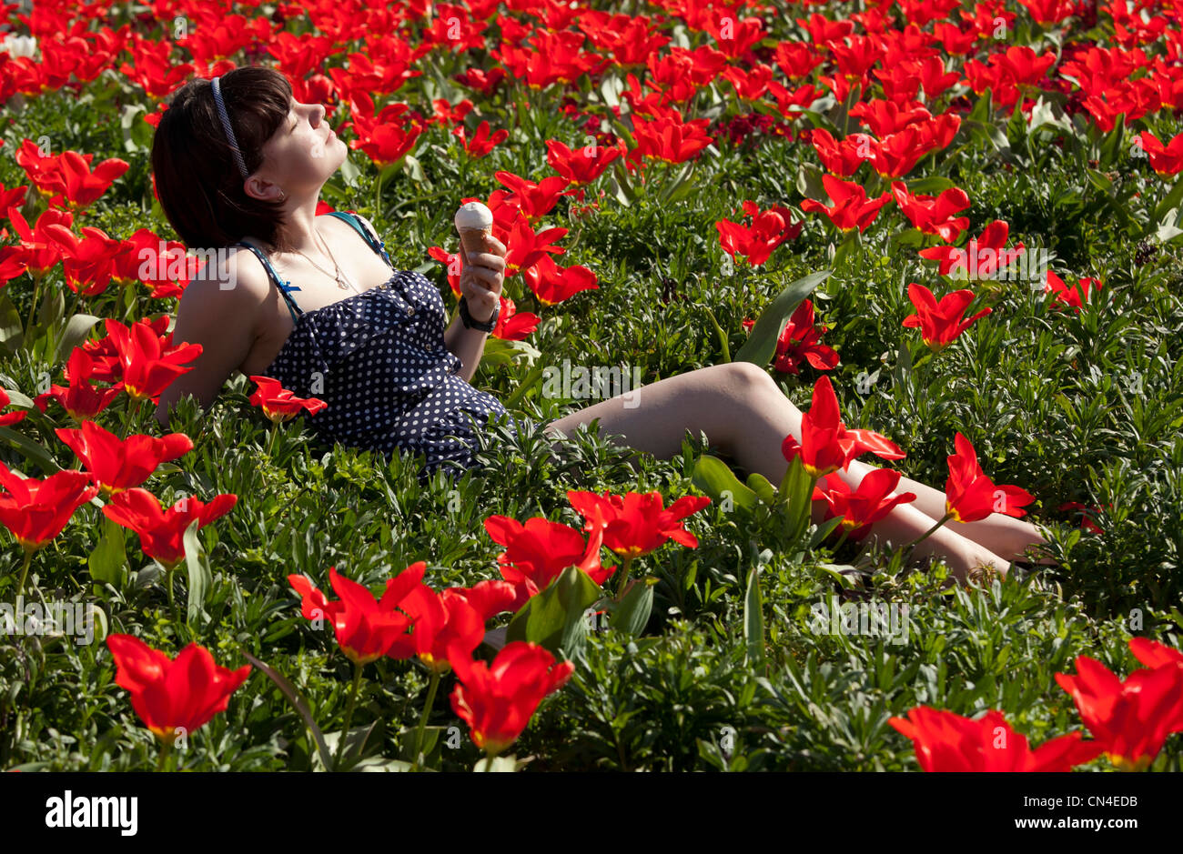 Una ragazza si trova in un mare di fiori nel centro di Stratford upon Avon su un insolitamente caldo giorno di marzo. Foto Stock