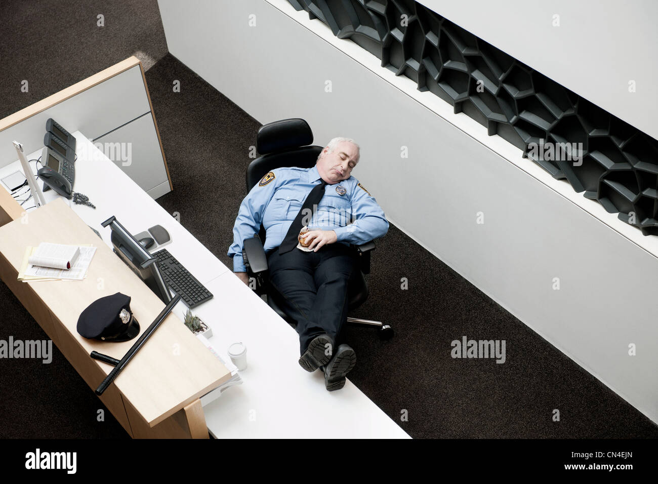 La guardia di sicurezza a dormire la scrivania Foto Stock