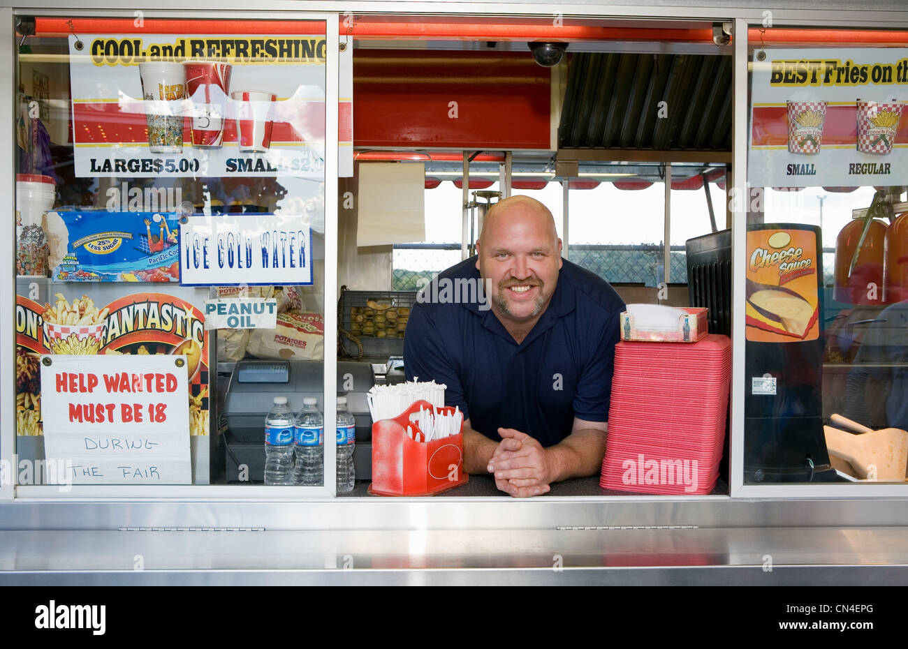 Proprietario del cibo stallo a county fayre, sorridente Foto Stock