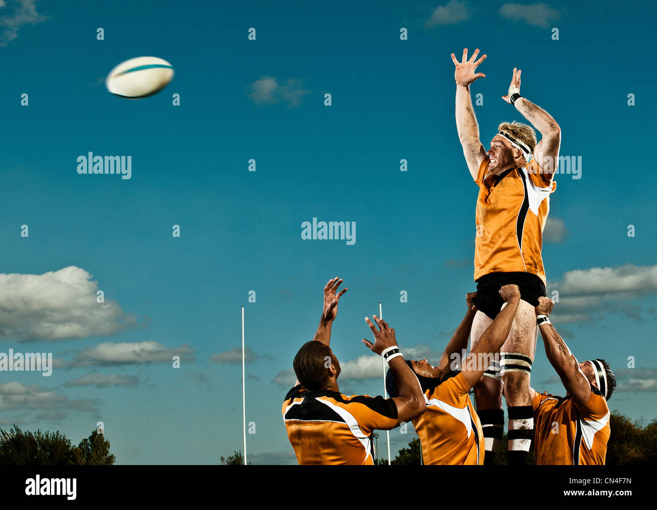 Giocatore di rugby che saltava fino alla sfera di cattura Foto Stock