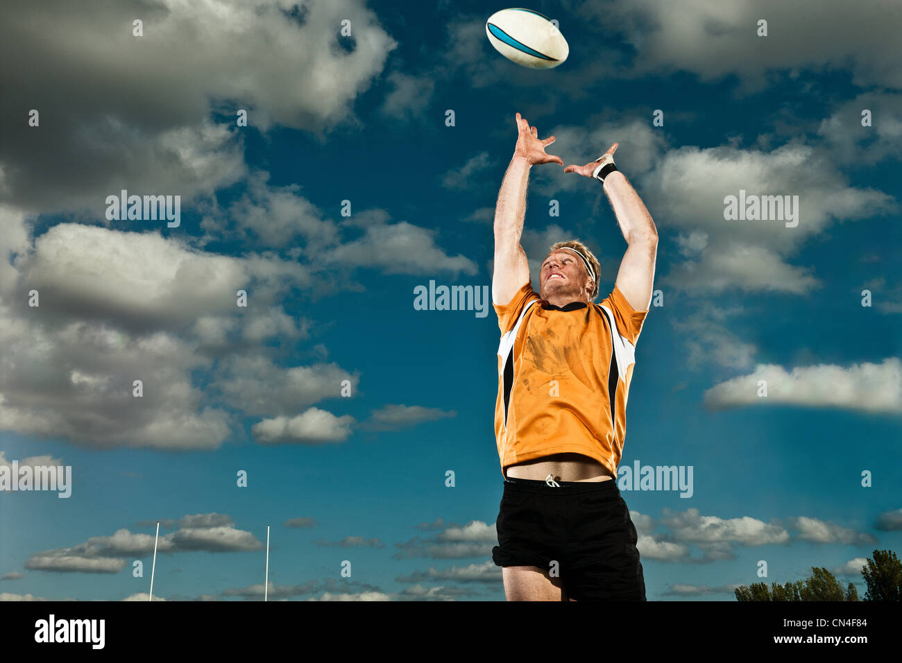 Giocatore di rugby che saltava fino alla sfera di cattura Foto Stock