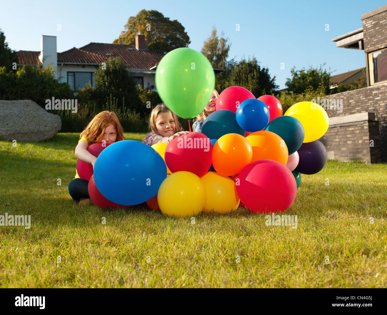 Le ragazze dietro i palloncini multicolori Foto Stock