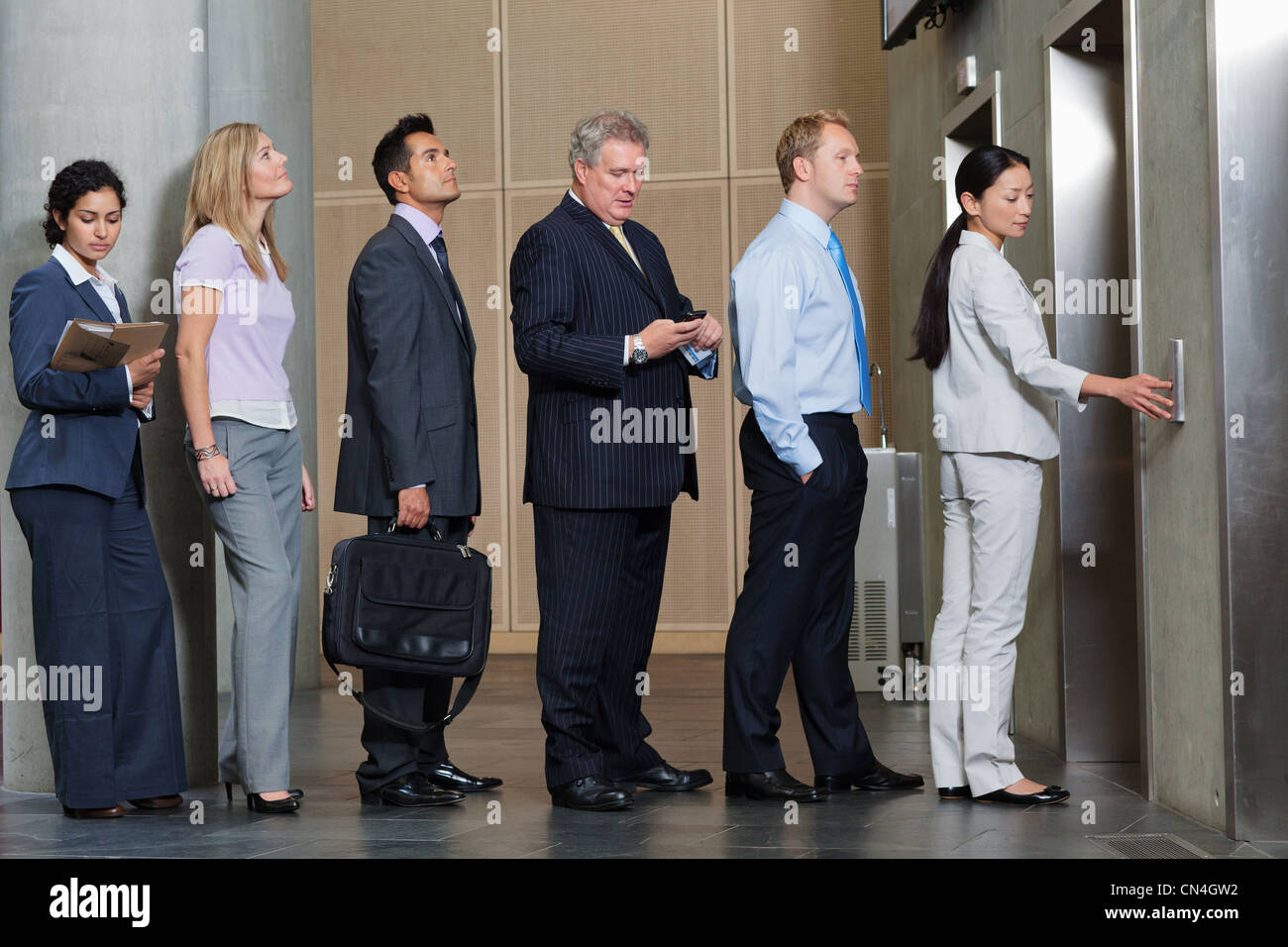Gli imprenditori in attesa nella coda per ascensore Foto Stock