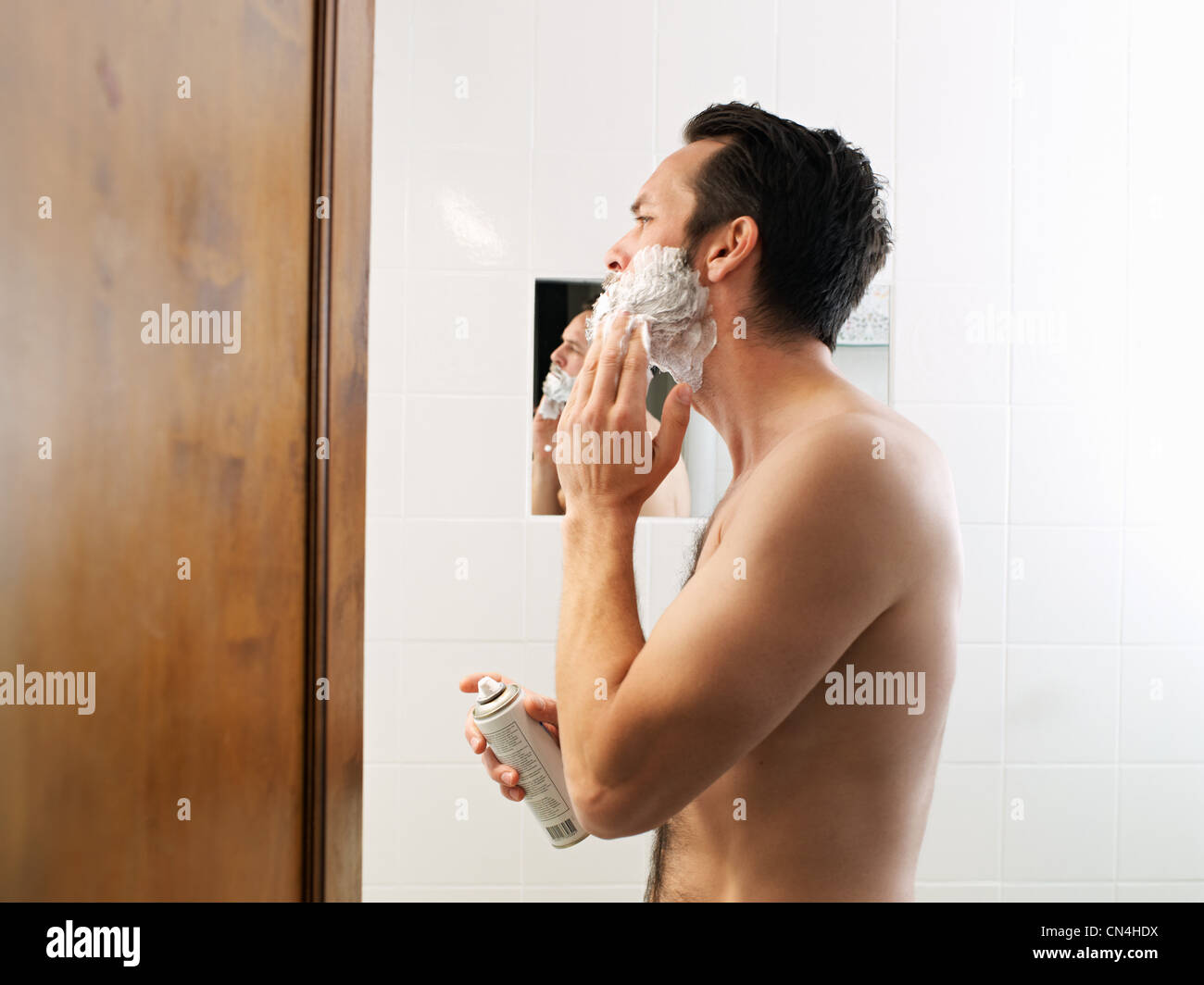 Uomo maturo applicazione di schiuma da barba in bagno Foto Stock
