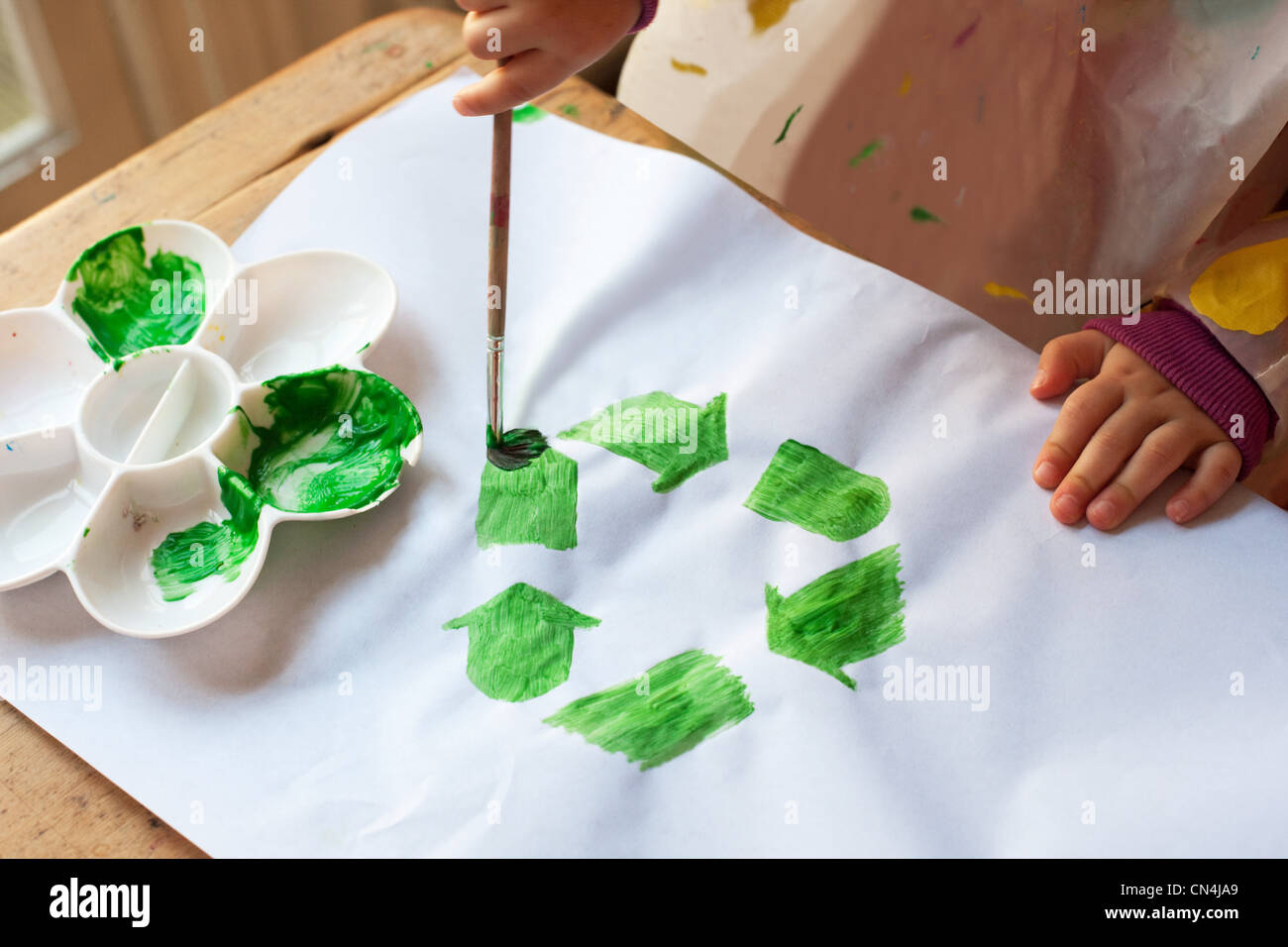 Bambino pittura verde simbolo di riciclaggio Foto Stock