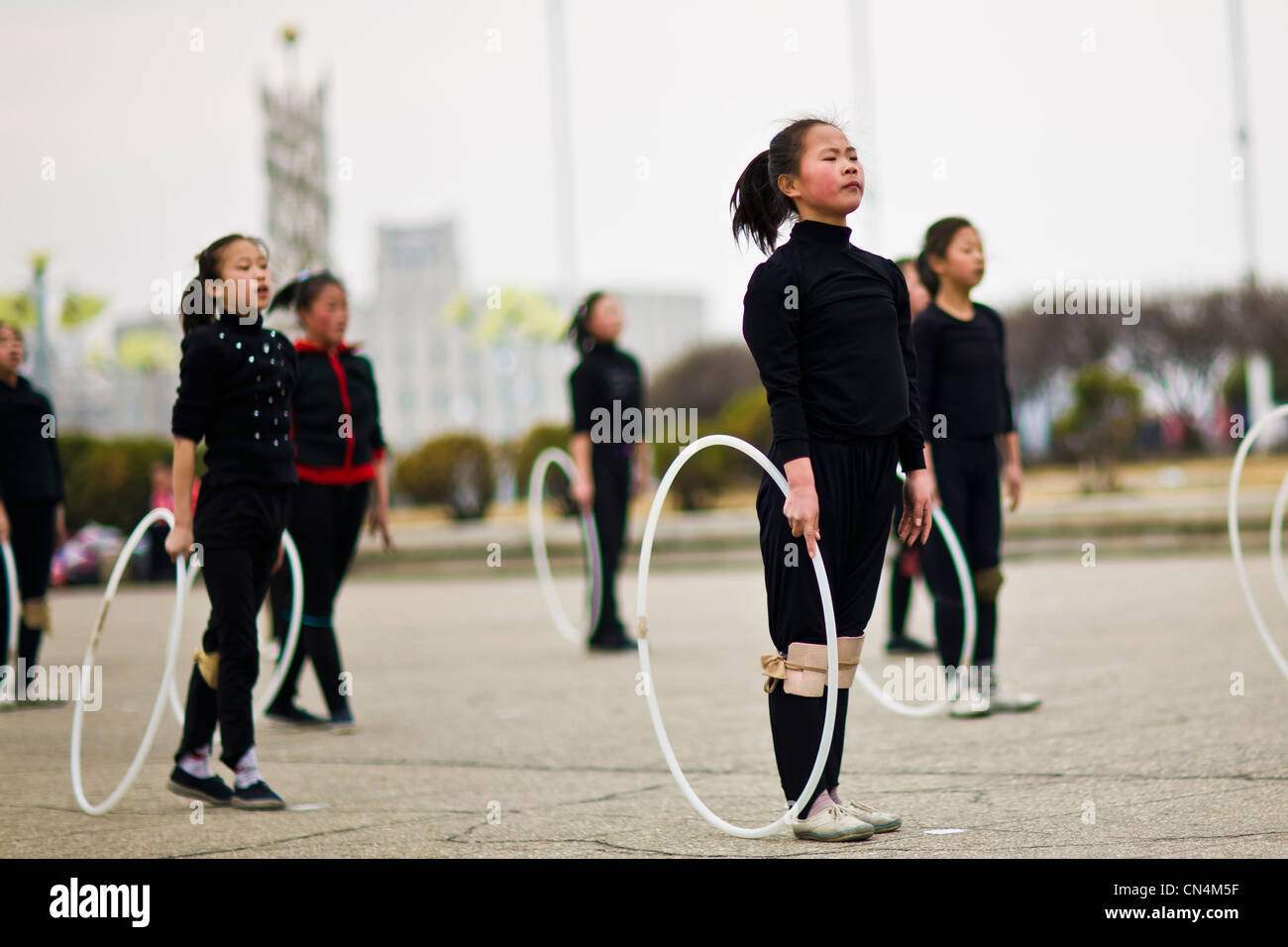 Corea del Nord Pyongyang, pattinaggio su ghiaccio, nord coreana ragazze ripassando per i giochi di Massa davanti a Pyongyang pista di pattinaggio sul ghiaccio Foto Stock