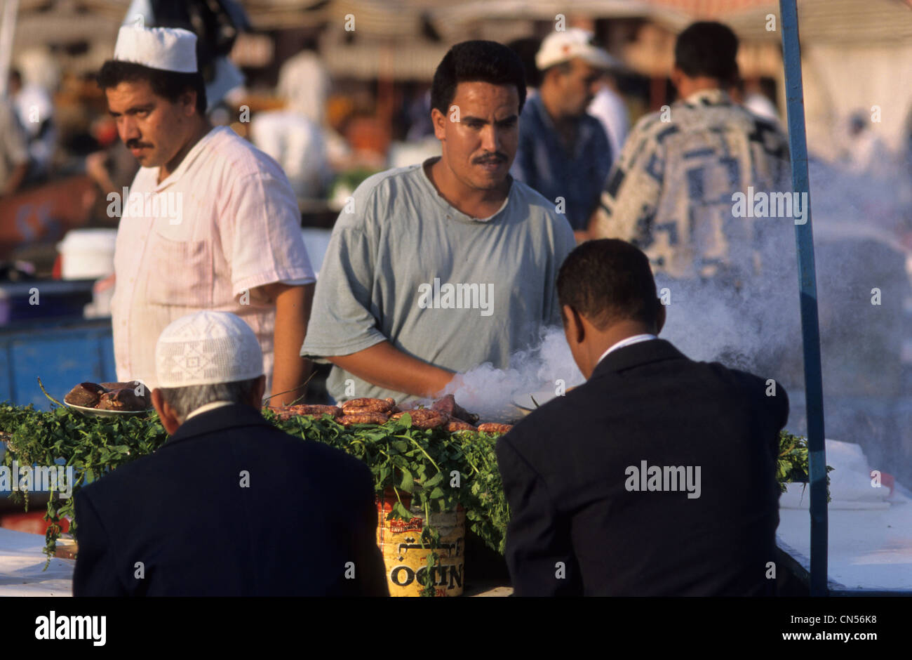 Persone di mangiare in un cibo in stallo durante il tramonto in piazza Jemaa el Fna a Marrakech, Marocco. Foto Stock