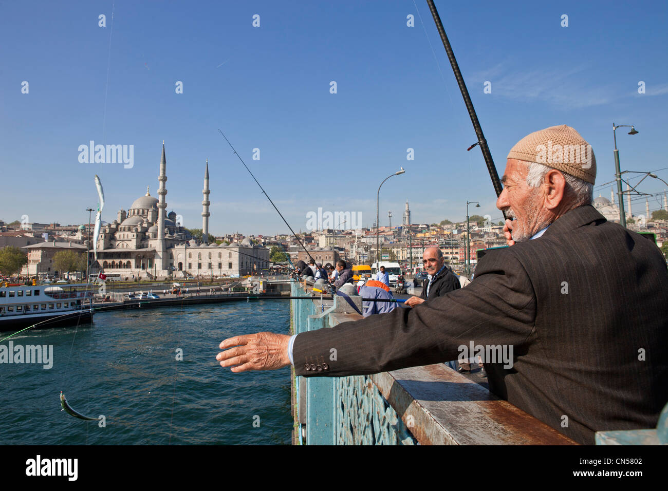 Turchia, Istanbul, pescatore sul Galata bridge spanning lo stretto del Golden Horn, sullo sfondo la Yeni Cami (Nuovo Foto Stock