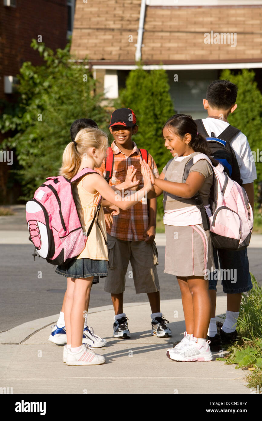 I bambini a giocare mentre si è in attesa per il bus di scuola, Toronto, Ontario Foto Stock