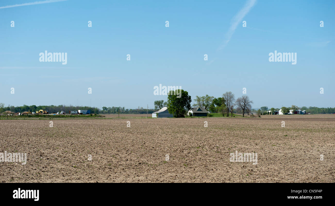 Arida terra agricola e la casa prima che i raccolti cominciano a crescere Foto Stock