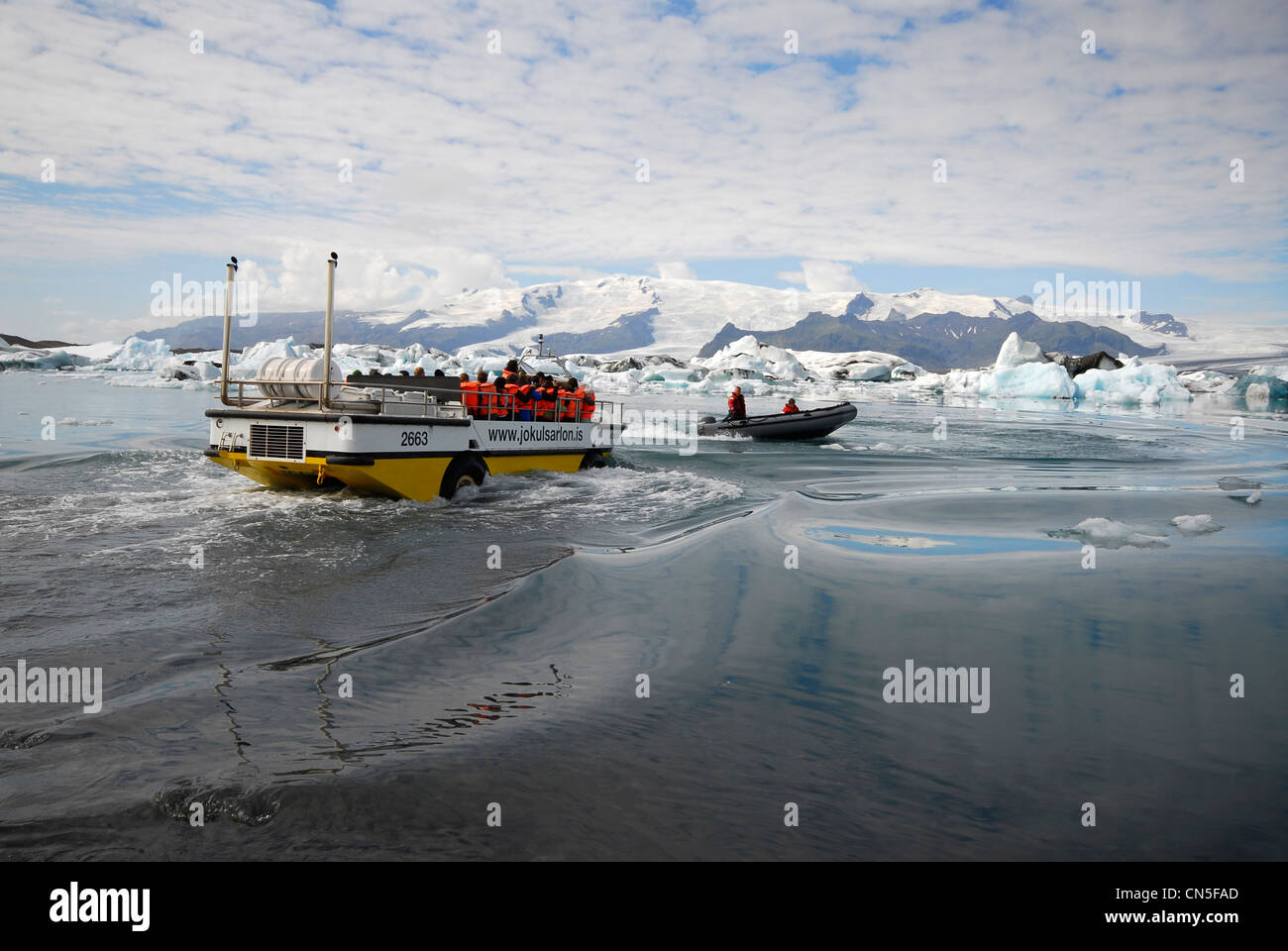 L'Islanda, Regione Austurland, veicolo anfibio per turisti di entrare il Jokulsarlon Lago glaciale preceduto da un Zodiac Foto Stock
