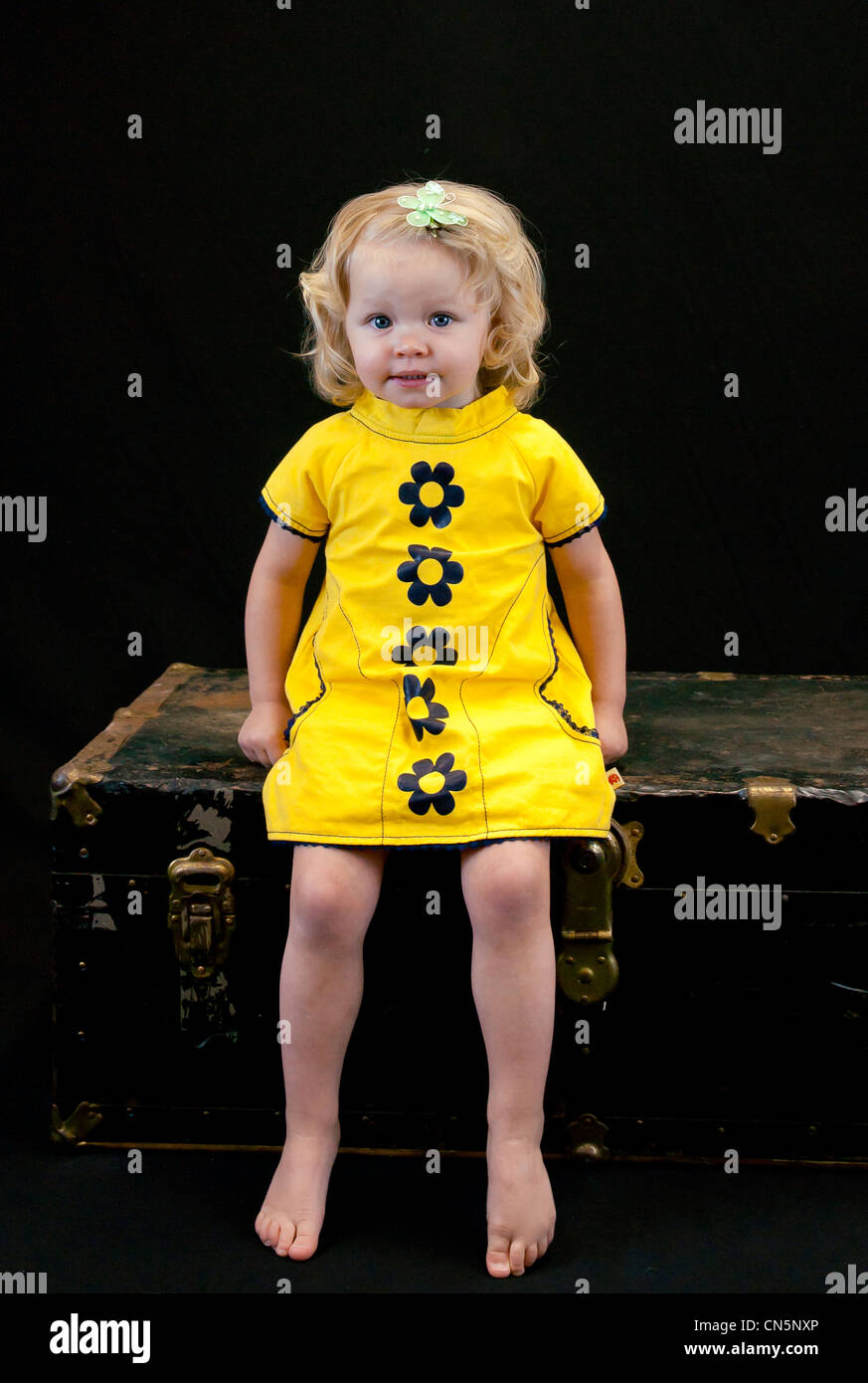 Abito giallo ragazza, butterfly capelli capelli ricci, seduta Foto Stock