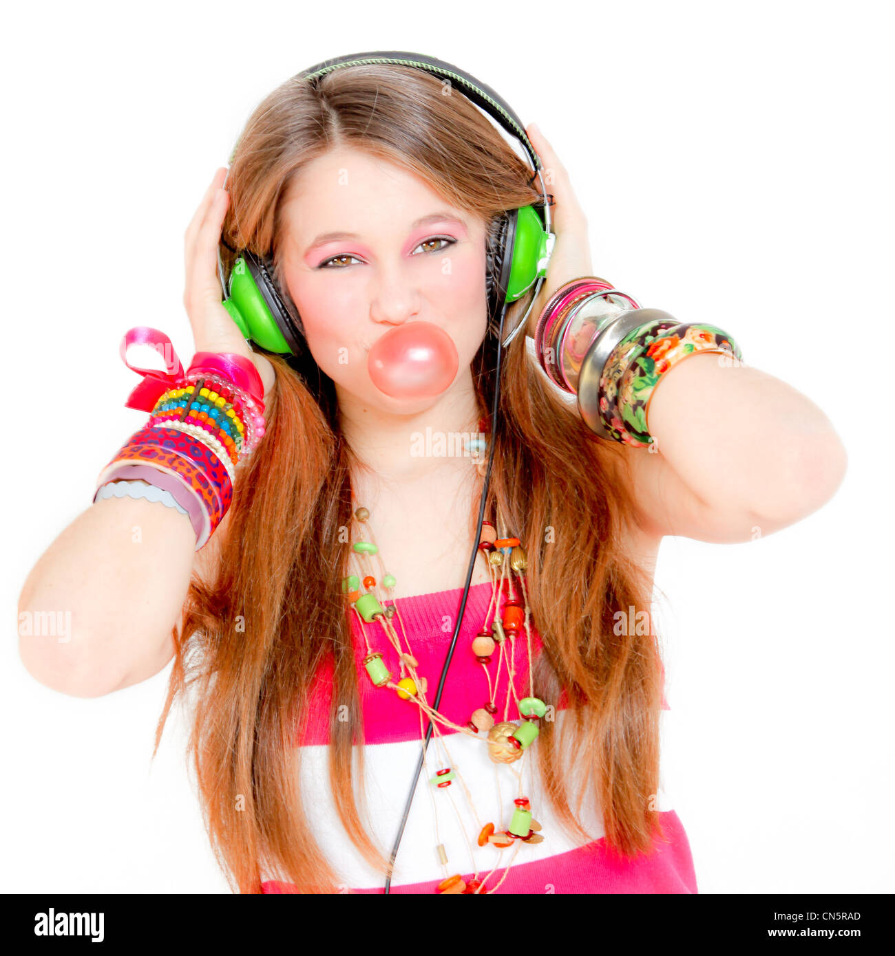 Young Teen girl ascoltando musica su cuffie e gomma di soffiatura Foto Stock