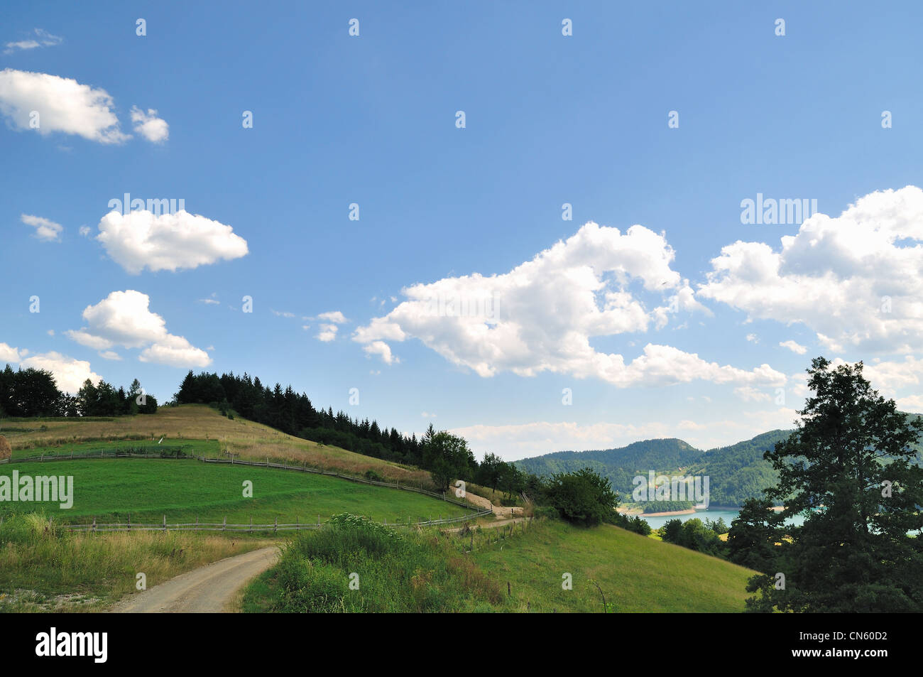 Piccolo paese di trogolo stradale campo e nuvole sul cielo blu Foto Stock