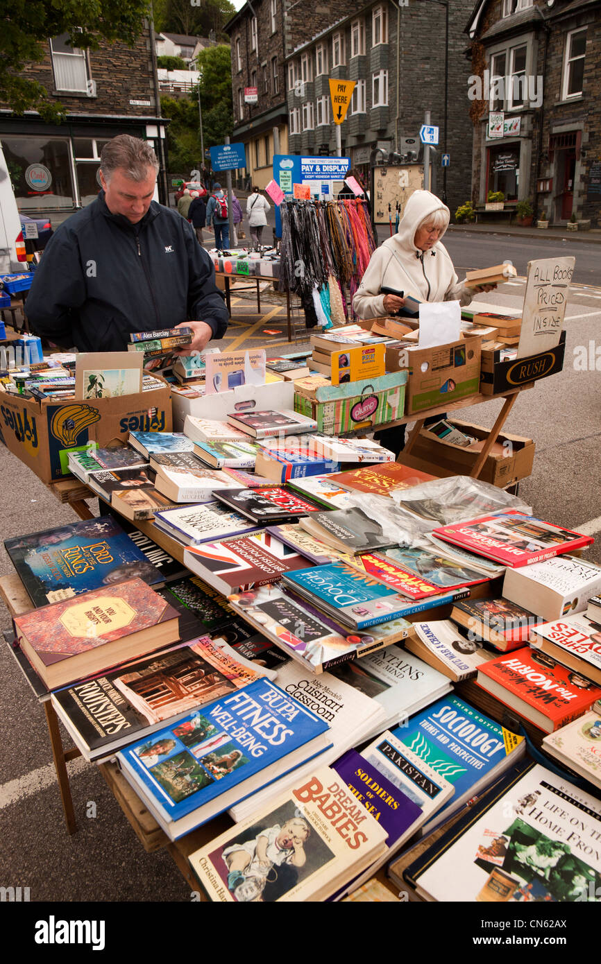 Regno Unito, Cumbria, Ambleside, King Street mercato all'aperto, gli acquirenti navigando in stallo del libro Foto Stock
