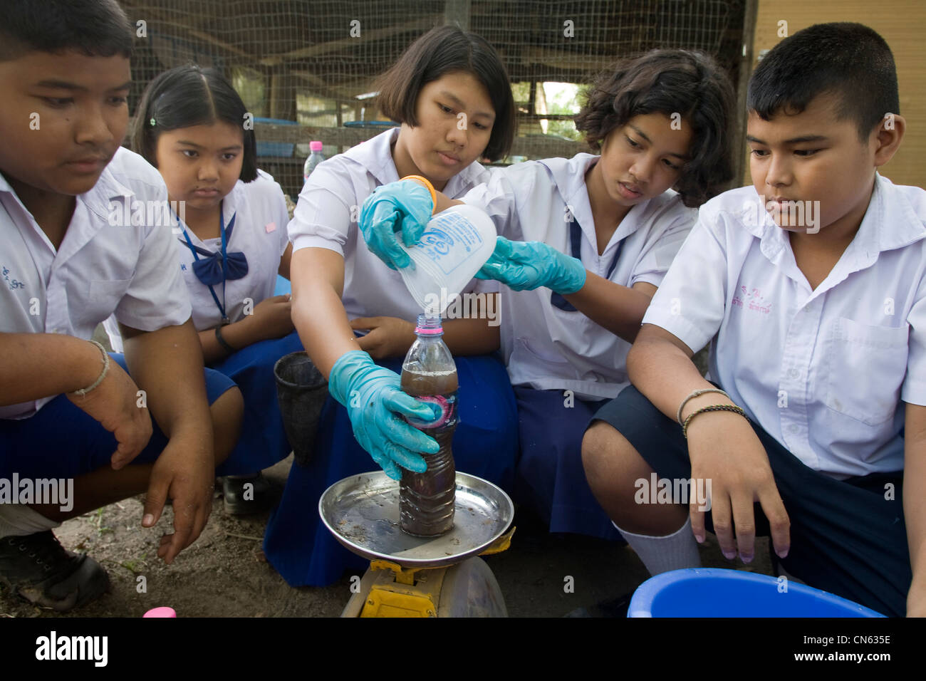 Alunni di una scuola elementare di Songkhla stanno rendendo liquido ferilizer da rifiuti vegetali. Della Thailandia Foto Stock