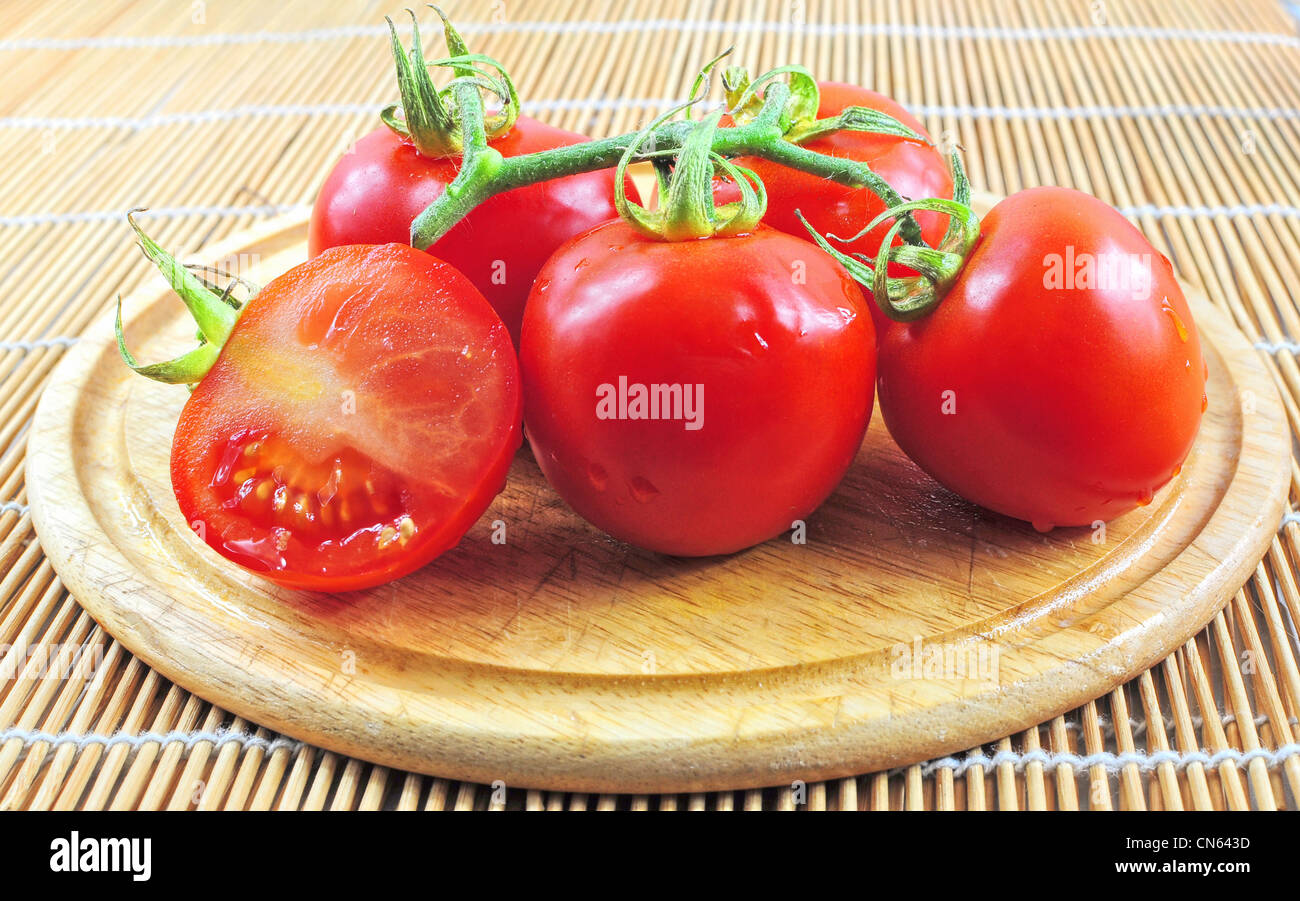 Il ramo di pomodori freschi sulla tavola di legno Foto Stock