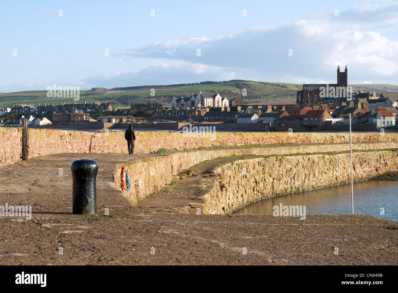 Uomo che cammina sul porto di Dunbar, Scotland, Regno Unito Foto Stock
