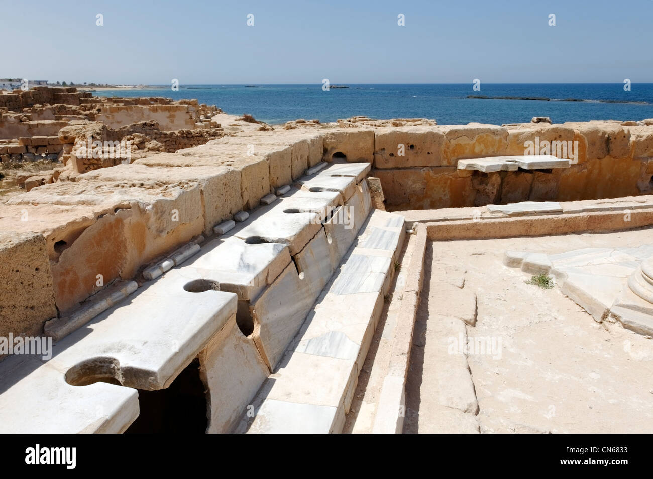 Sabratha. La Libia. Vista di alcune della fine del primo secolo sedi di latrina esagonale che è pavimentato e rivestito con belle Foto Stock