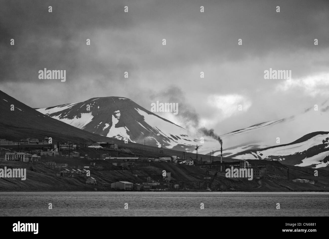 Norvegia Isole Svalbard, isola Spitsbergen, fumo nero flutti dal forno a combustione di carbone in russo insediamento minerario di Barentsburg Foto Stock