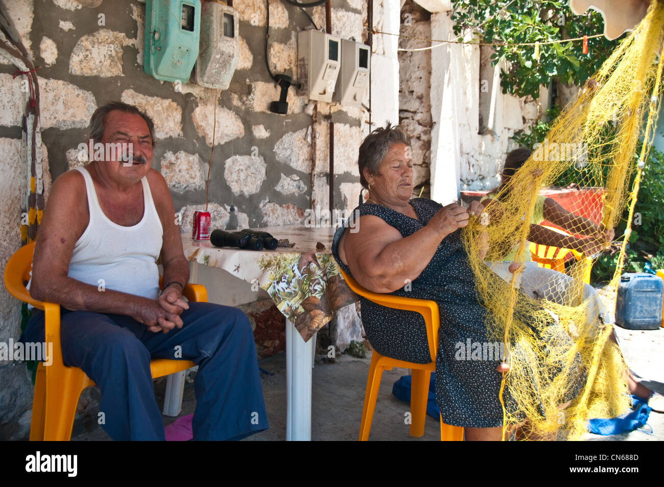 Il marito e la moglie in Grecia riassettavano le reti da pesca. Foto Stock