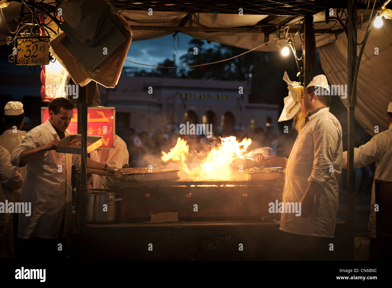 I cuochi in un cibo stallo del Djemaa El Fna di Marrakech, Marocco. Foto Stock