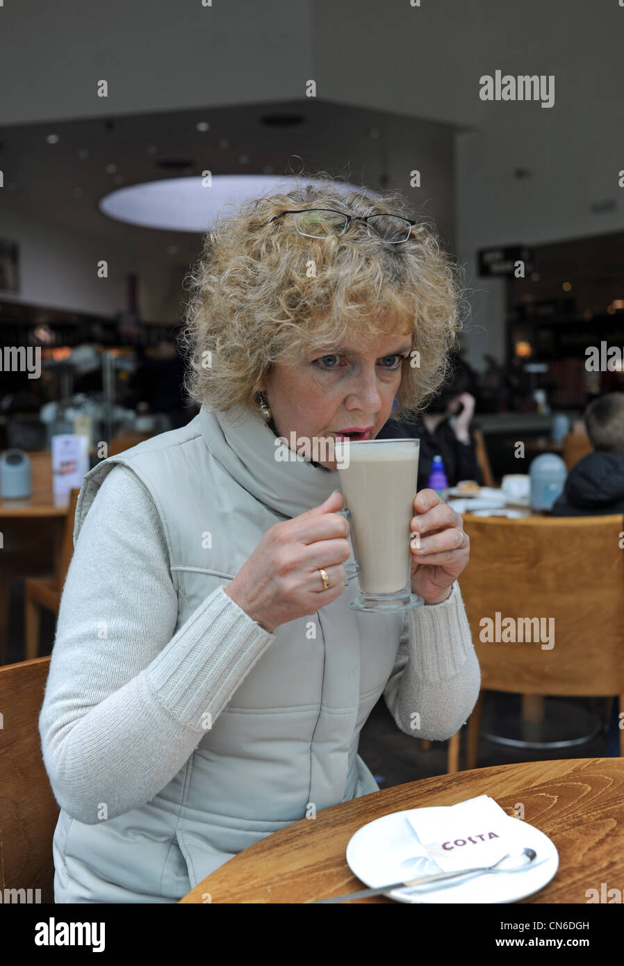 Donna bere un caffè Costa presso i servizi autostradali REGNO UNITO Foto Stock