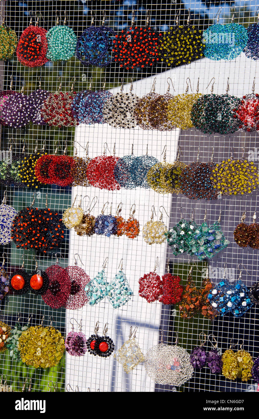 Molte colorate orecchini fatti a mano per la vendita in fuori strada del mercato equo. Foto Stock