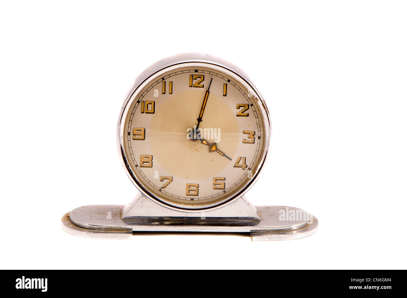 Antica retrò vintage metallo orologio mostrano qualche minuto passato quattro isolati su sfondo bianco. Foto Stock