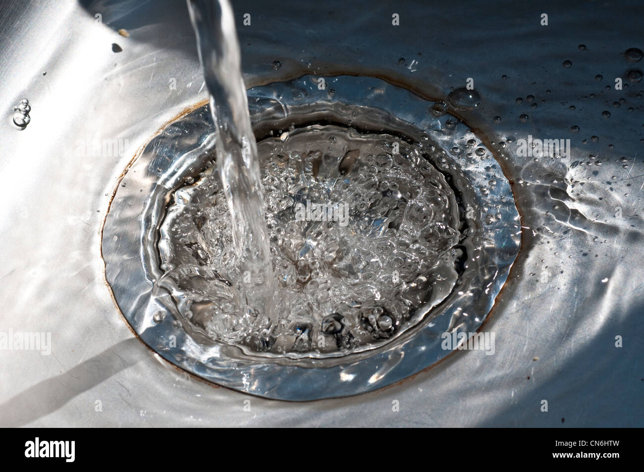 Acqua versando in un foro del dissipatore Foto Stock