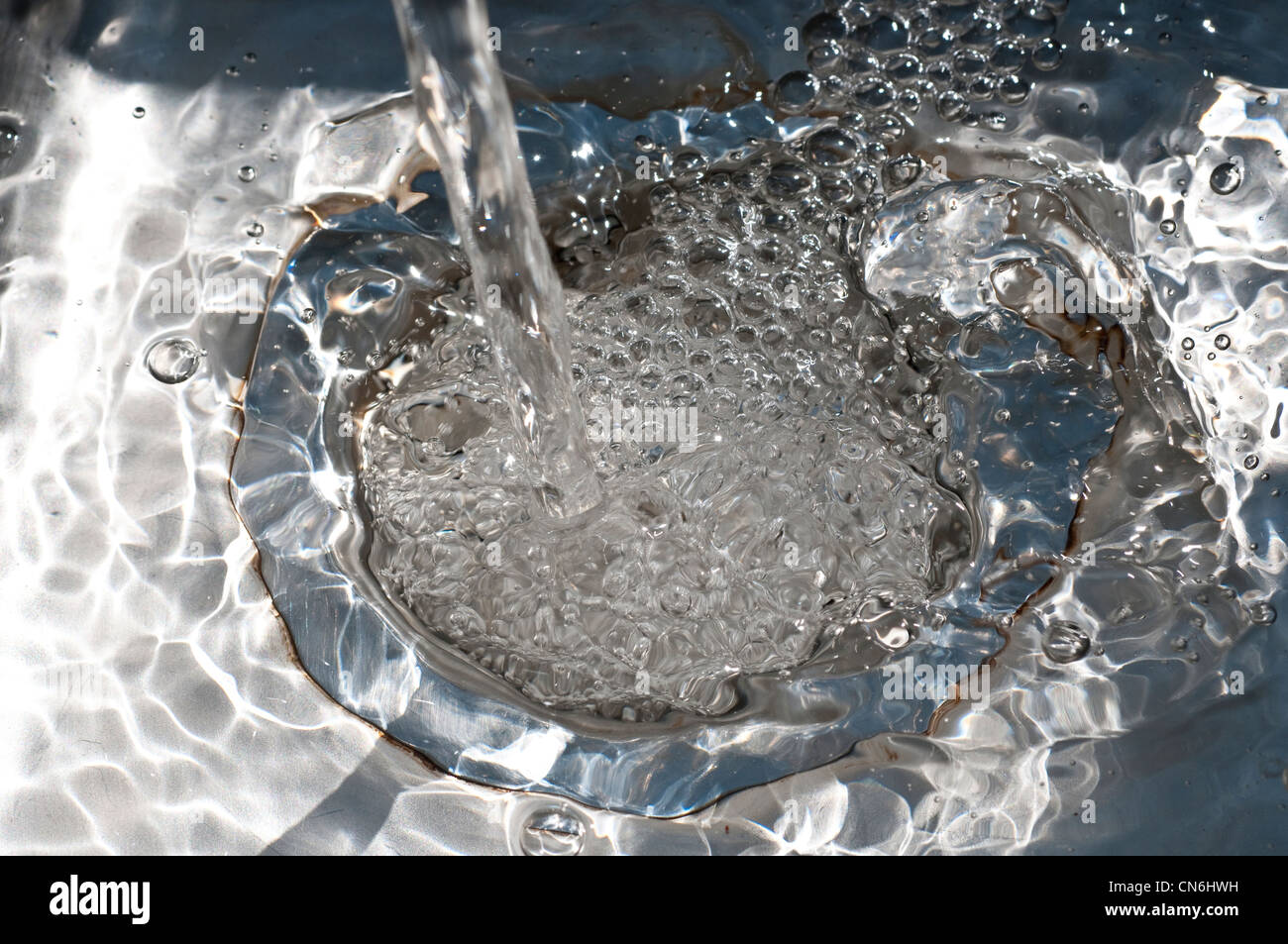 Acqua versando in un foro del dissipatore Foto Stock