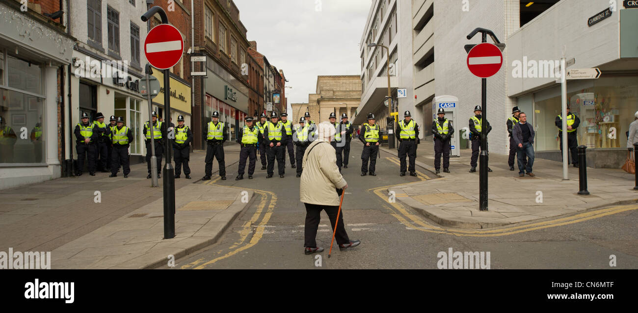 Una vecchia donna cammina davanti a un cordone di polizia per i liberali democratici Conferenza a Sheffield Foto Stock