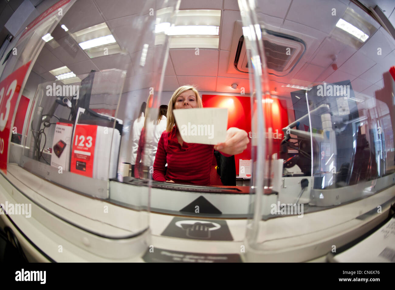 Una donna bancomat presso una filiale di Santander high street bank, REGNO UNITO Foto Stock