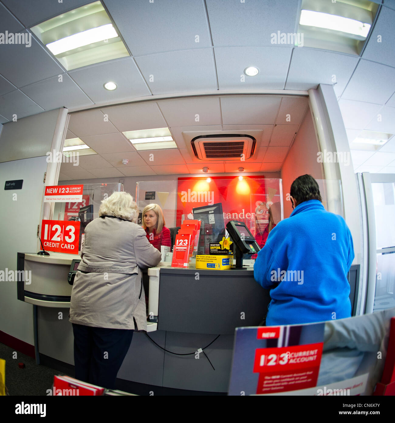 I clienti e le donne degli scrutatori presso una filiale di Santander high street bank, REGNO UNITO Foto Stock