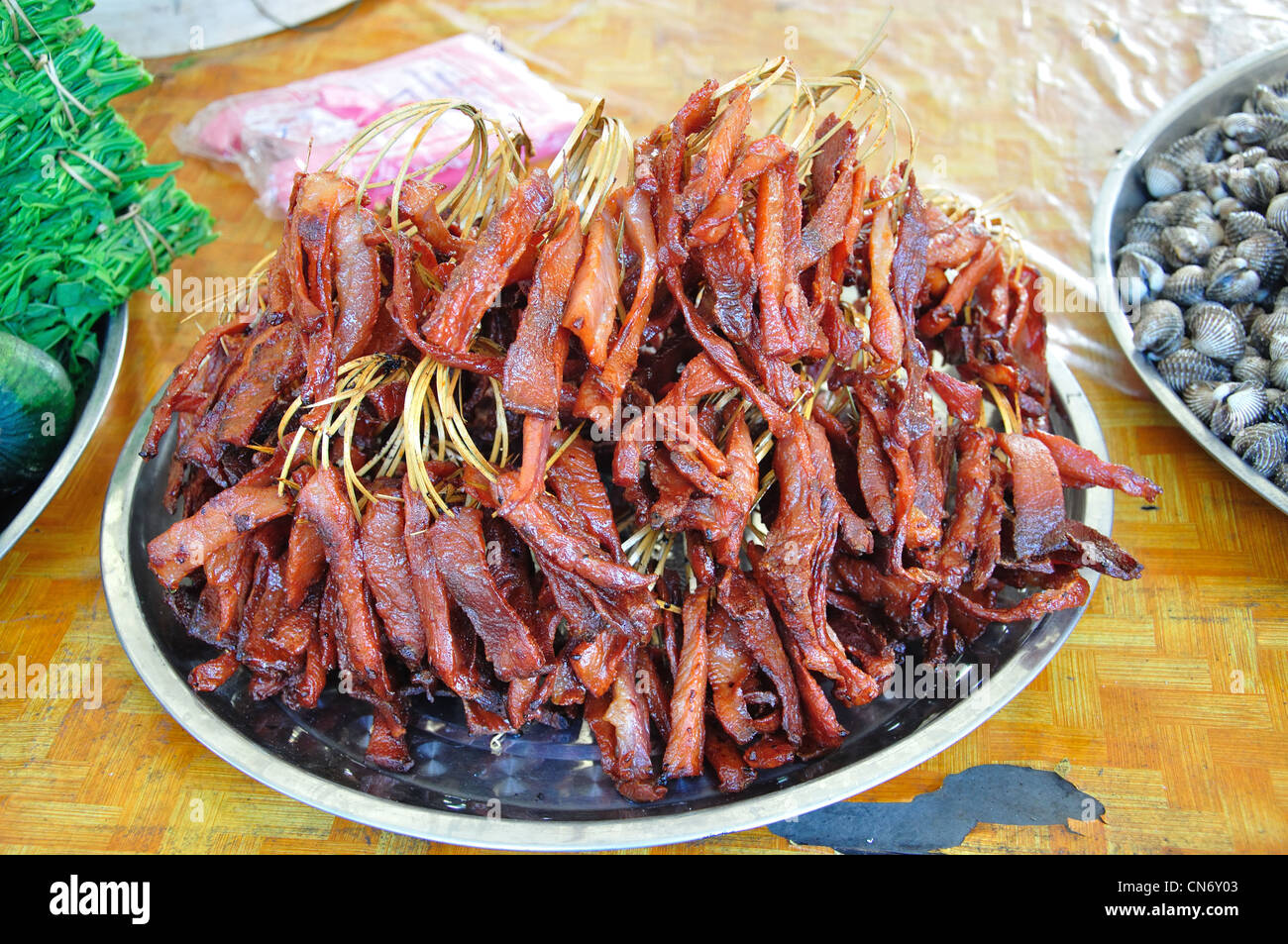 Cuocere le strisce di carne di maiale in street market alimentare, Ban Nongbone, Vientiane, prefettura di Vientiane, Laos Foto Stock