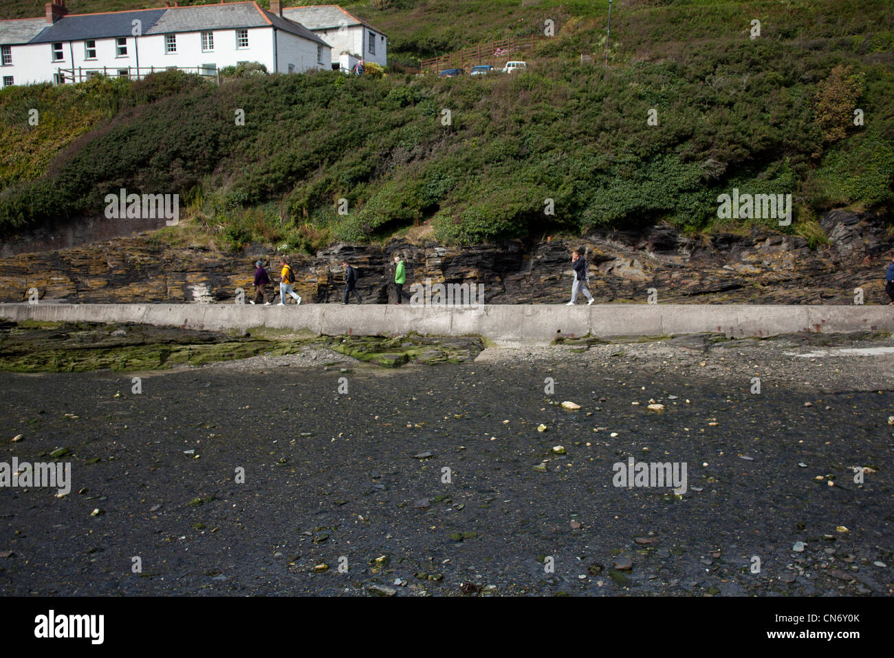 Una famiglia passeggiate lungo la parete del porto a boscastle Cornwall in vacanza. Foto Stock