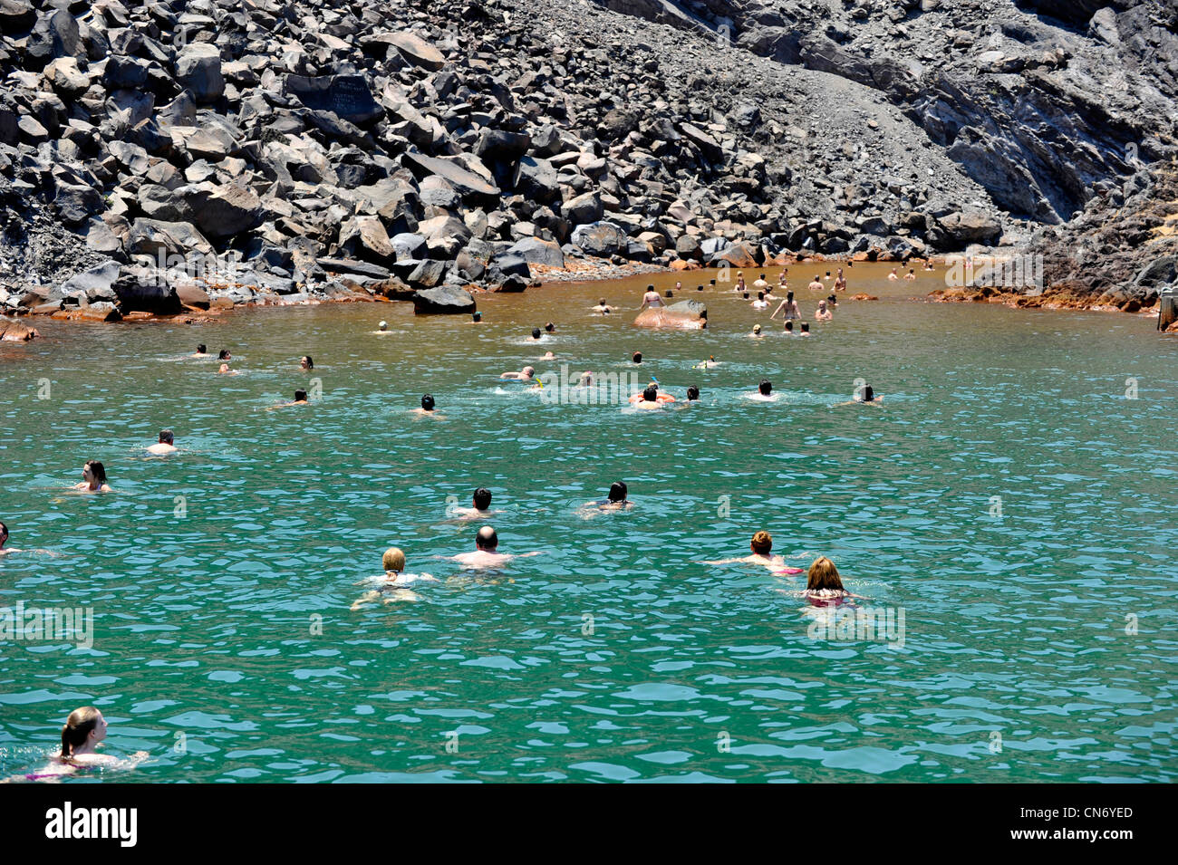 Europa Grecia CICLADI Santorini bagnanti nuotare verso la zona di acqua ​​sulfurous nel vulcano Nea Kameni Foto Stock