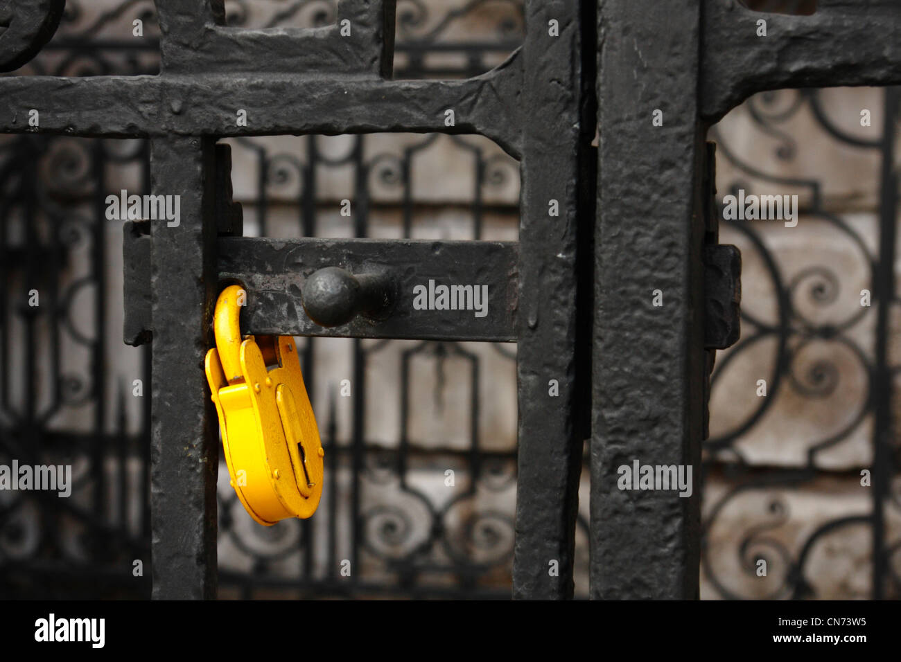 Lucchetto giallo su un black metal di gate, la Cattedrale di St Paul, Londra Foto Stock