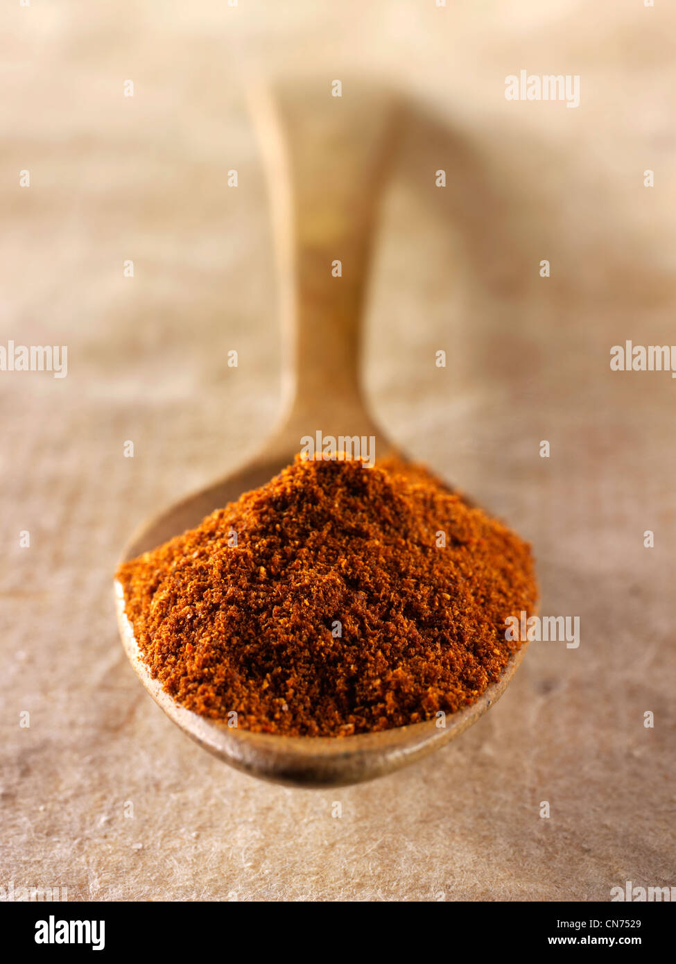 Cayenne spezie in polvere powderin un cucchiaio di legno contro uno sfondo naturale Foto Stock