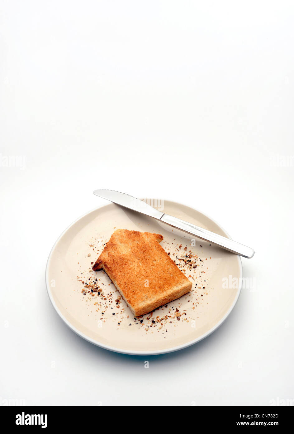 Pezzo di pane tostato in forma di casa sulla piastra con coltello alloggiamento nuovamente la proprietà di mercato di acquistare casa gli acquirenti prima volta case costa ETC REGNO UNITO Foto Stock