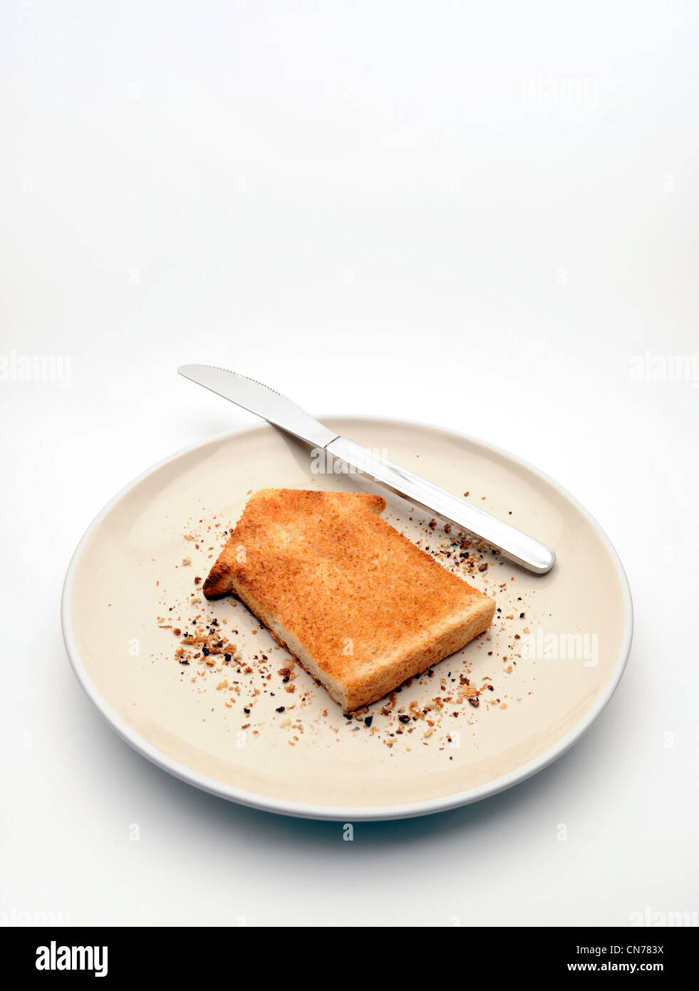 Pezzo di pane tostato in forma di casa sulla piastra con coltello alloggiamento nuovamente la proprietà di mercato di acquistare casa gli acquirenti prima volta case costa ETC REGNO UNITO Foto Stock