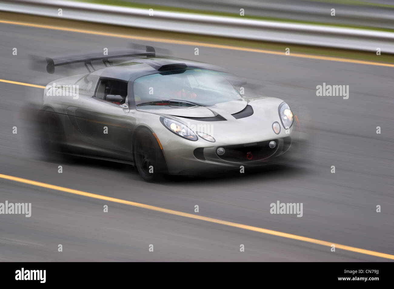 Un argento veloce auto sportiva di accelerare la strada. Una leggera sfocatura di movimento. Foto Stock