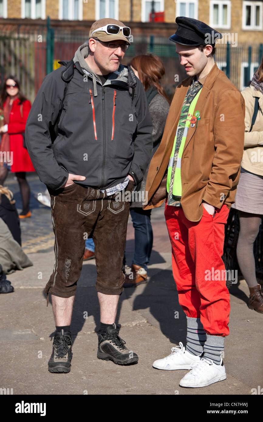 A piena lunghezza ritratto di due uomini alla moda parlare e permanente sulla strada, Columbia Road, London, England, Regno Unito Foto Stock