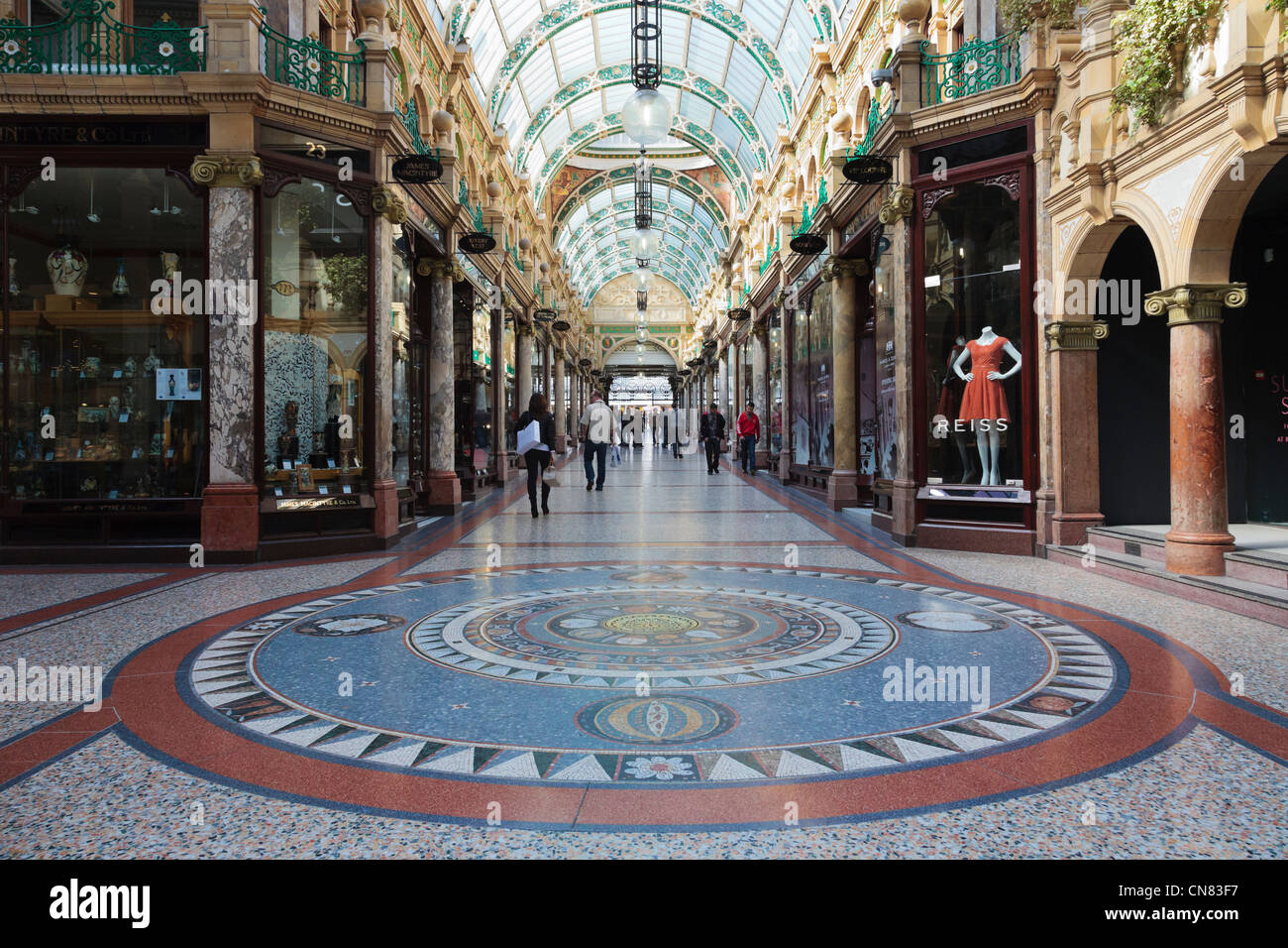 Pavimento a mosaico e la tradizionale sistemazione di negozi di designer nella contea di Arcade nel quartiere di Victoria shopping centre in Inghilterra Leeds REGNO UNITO Foto Stock