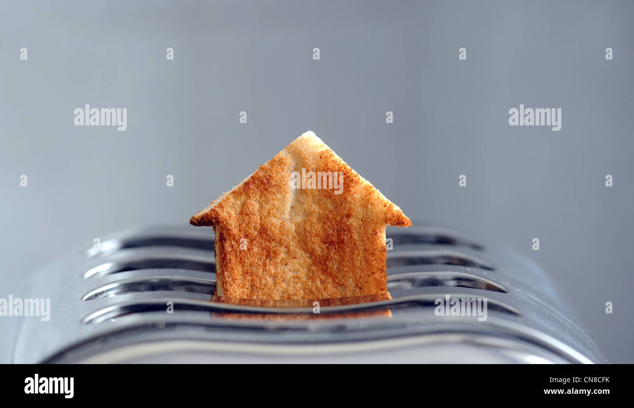 Pezzo di pane tostato in forma di casa nel tostapane RE alloggiamento proprietà di mercato di acquistare casa gli acquirenti prima volta case costa ETC REGNO UNITO Foto Stock