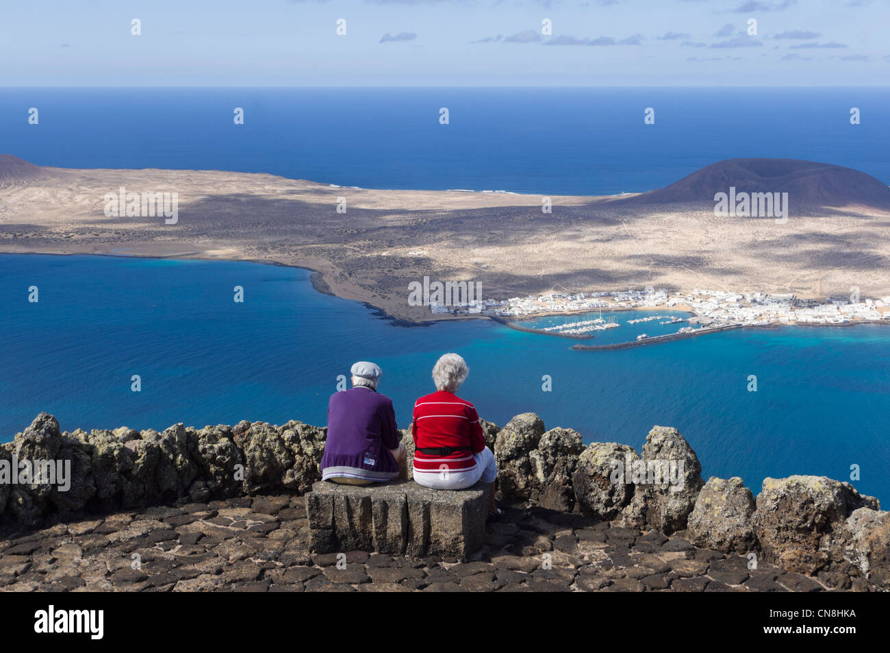 Lanzarote - Isla de la Graciosa. La vista dal Mirador del Rio, con la porta di Caleta de Sebo sull isola. Coppia al Mirador. Foto Stock