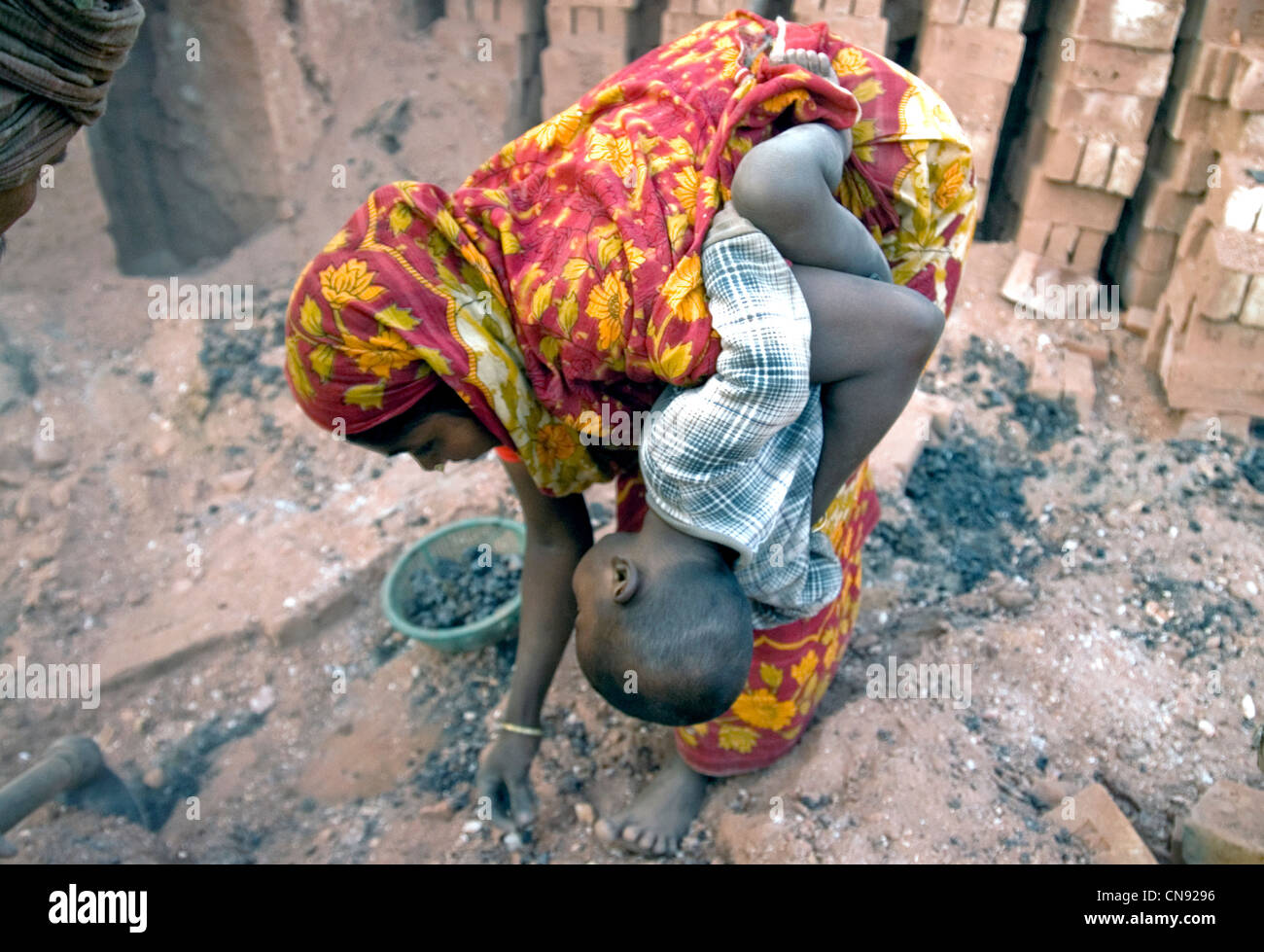 Donna con bambino lavorando in Bangladesh Fatullah fabbrica di mattoni Foto Stock